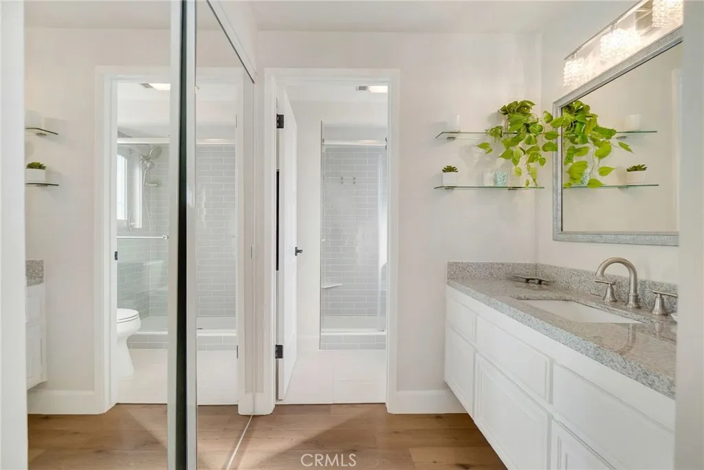 Ensuite bathroom featuring spacious vanity with ample cabinetry, large mirror and walk in closet window sliding doors and entry into private toilet and walk in shower area. Ensuite bathroom featuring spacious vanity with ample cabinetry, large mirror and walk in closet window sliding doors and entry into private toilet and walk in shower area.