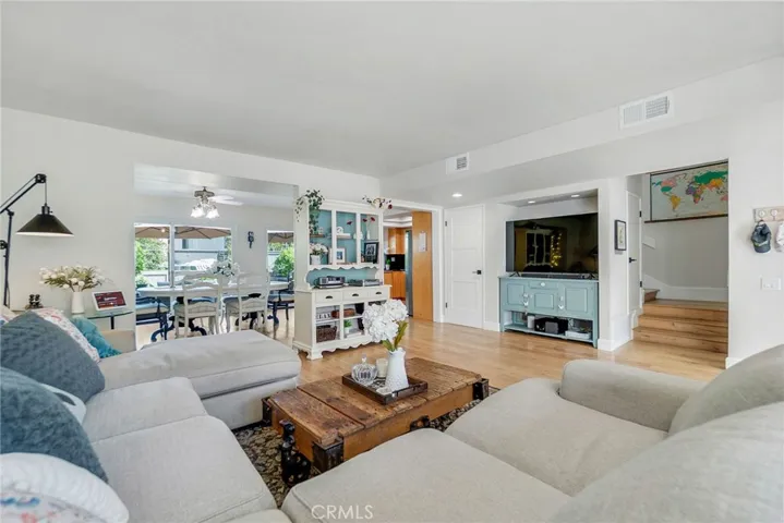 Living room towards dining room, kitchen and stairs to second story of home.