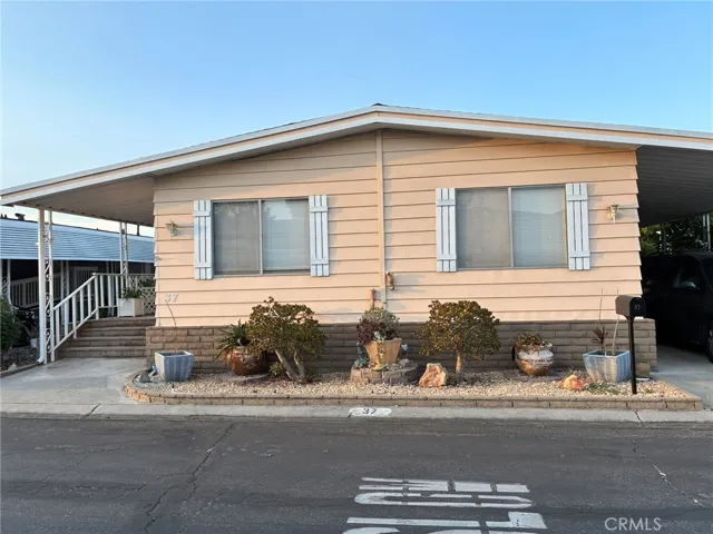 Looking from across the street extra large wide private roads and ample parking under white covered tandem parking car lot and leads to laundry room entry way with a guest or second bathroom steps from the carport
