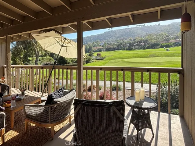 Golf course views are visible from the covered deck, living/dining area, primary suite and second bedroom."