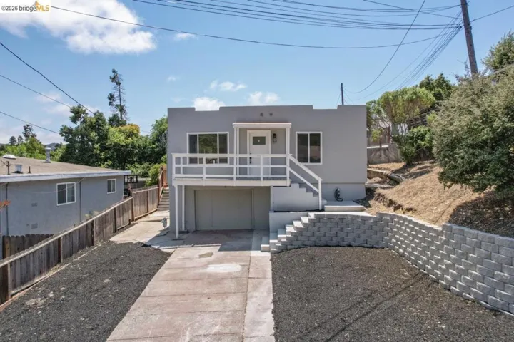 View of front of home featuring stucco siding, an attached garage, and concrete driveway