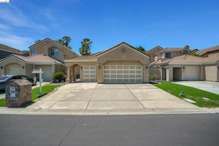 Stucco exterior with a tiled roof, two-car garage, and an additional single-car garage