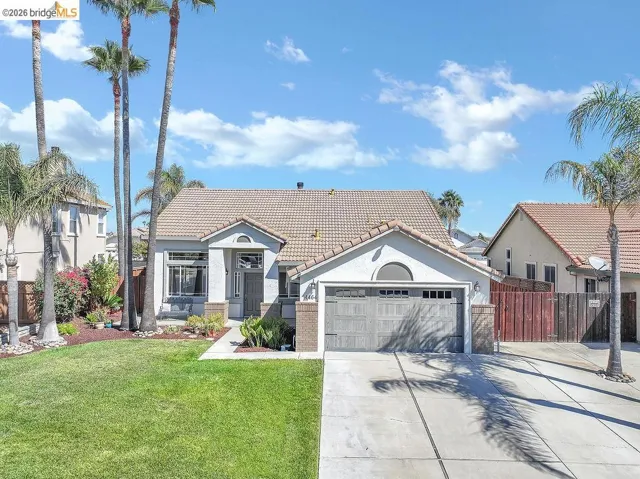 Single-story residence featuring a tile roof, an integrated garage, and a concrete driveway