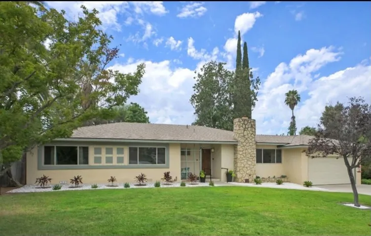 Classic mid-century modern featuring a brand-new roof, striking stone chimney and exceptional curb appeal.