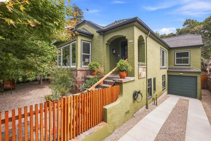 Stucco exterior with a pitched roof, attached single-car garage, and a gated entryway