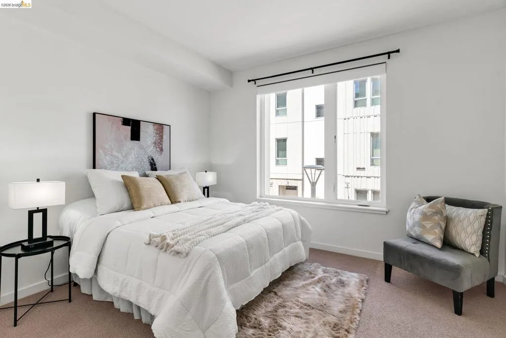 Bright room featuring a large window, neutral wall tones, and carpet flooring