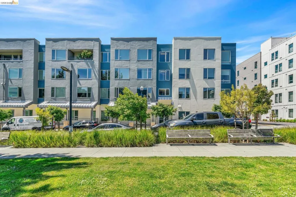Contemporary multi-story facade featuring varied paneling, expansive windows, and a private balcony