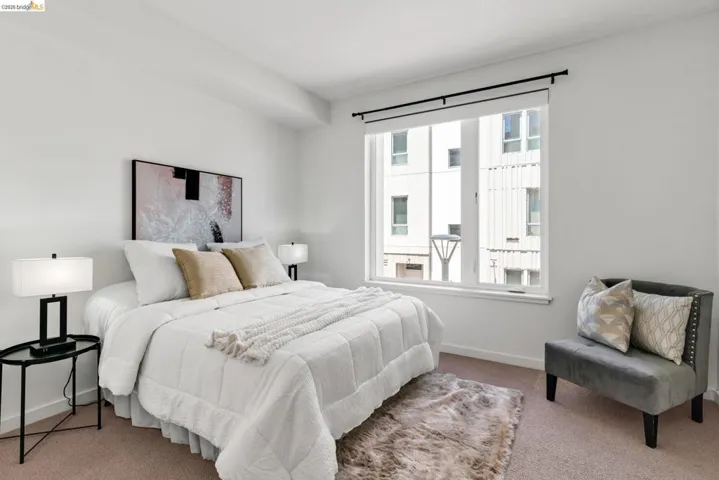 Bright room featuring a large window, neutral wall tones, and carpet flooring
