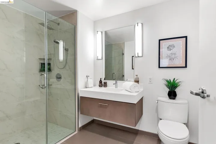 Modern bathroom featuring a frameless glass shower enclosure with subway tile surround and built-in niche