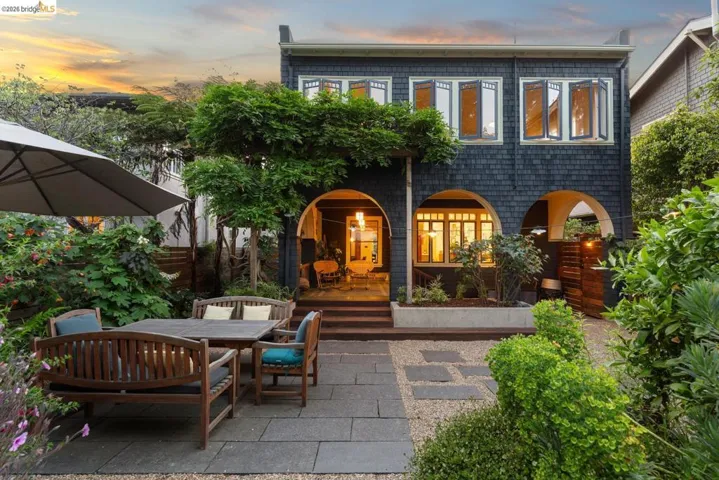 Expansive outdoor patio featuring flagstone pavers, gravel accents, and mature plantings