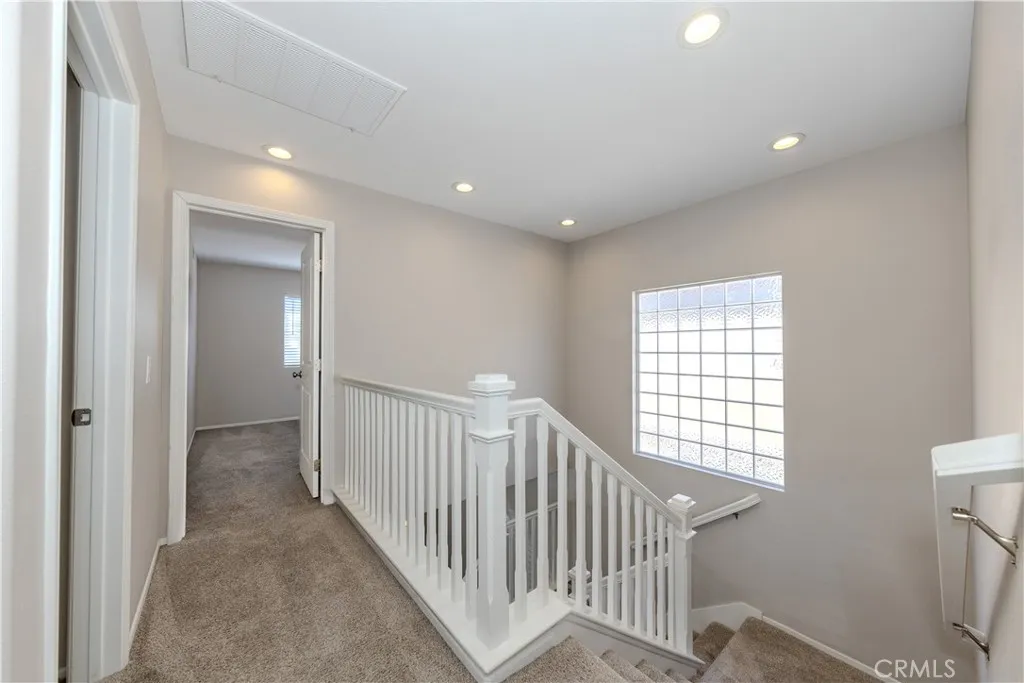 Upstairs hallway. Secondary bedrooms straight ahead and primary bathroom behind you.