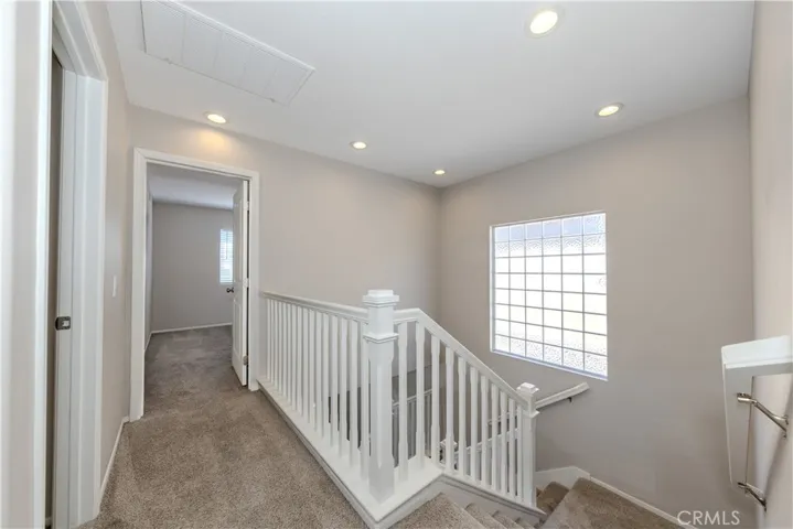 Upstairs hallway. Secondary bedrooms straight ahead and primary bathroom behind you.