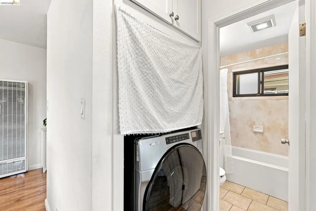 Stackable laundry appliances beneath white shaker-style cabinetry