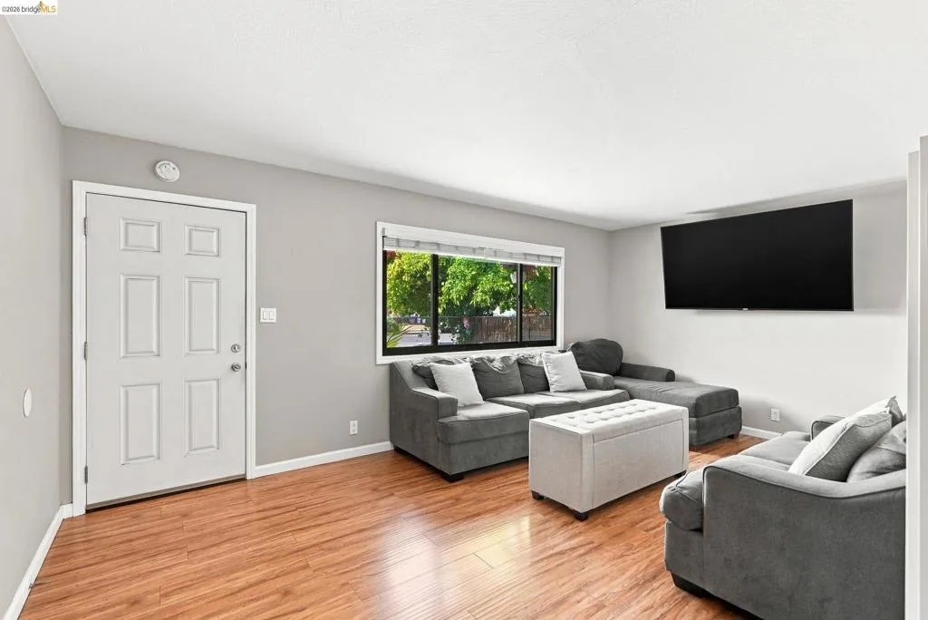 Warm wood-finish flooring complements light gray walls