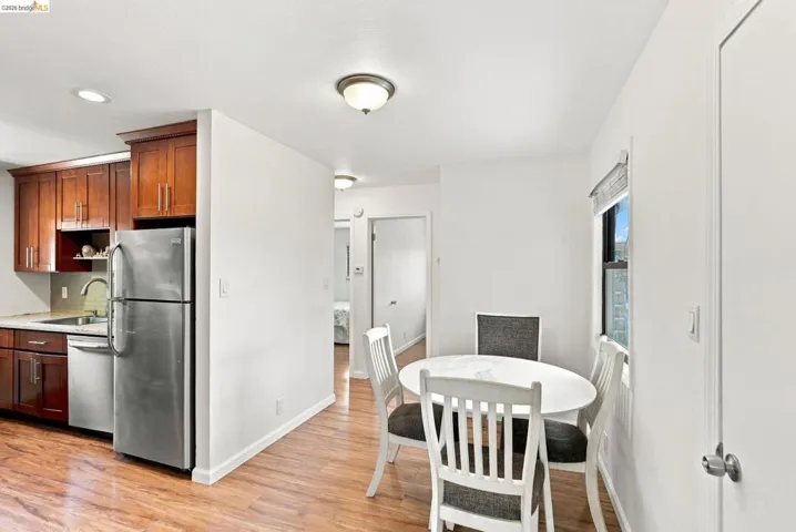 Kitchen featuring wood-finish flooring, stainless steel appliances, and dark wood cabinetry