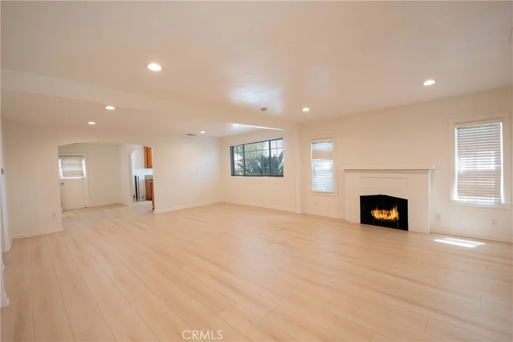 Light-filled living room featuring new flooring and fresh interior paint.