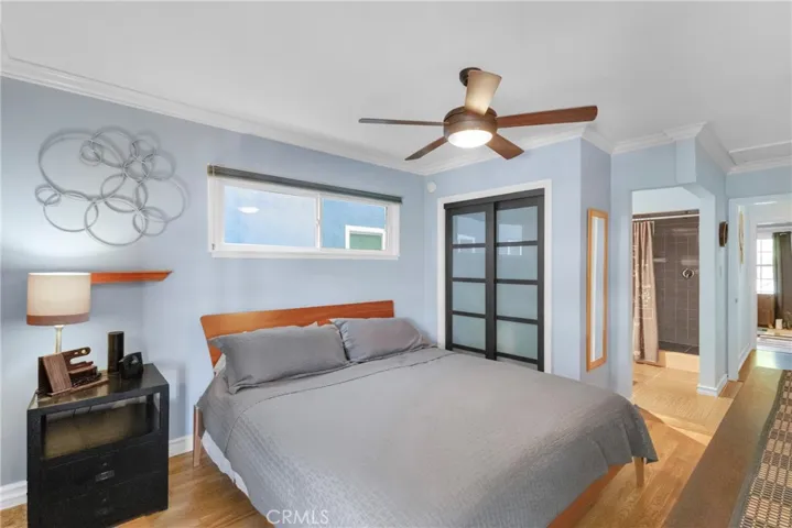 Primary bedroom with ceiling fan and stylish closet doors