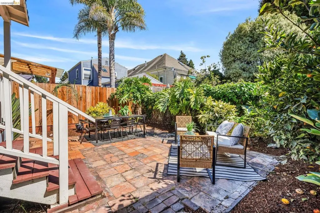 Brick paver patio with a wood privacy fence and lush perimeter landscaping