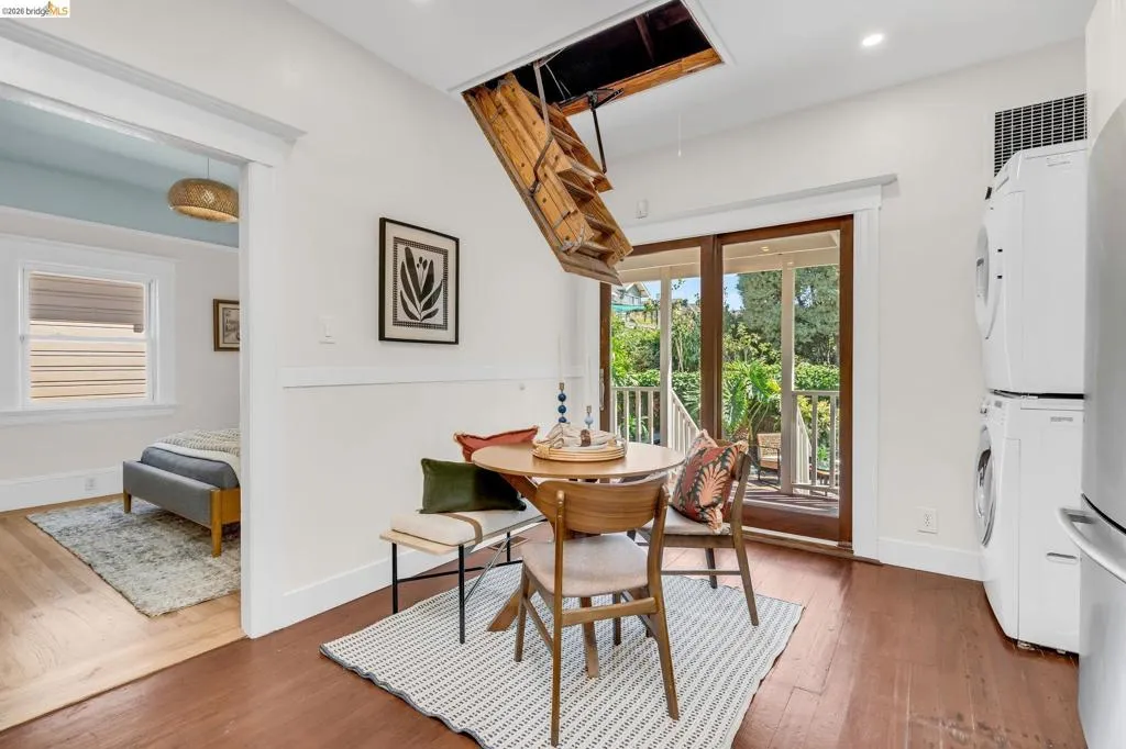 Dark wood-finish flooring with white baseboards, white walls, and a recessed light fixture