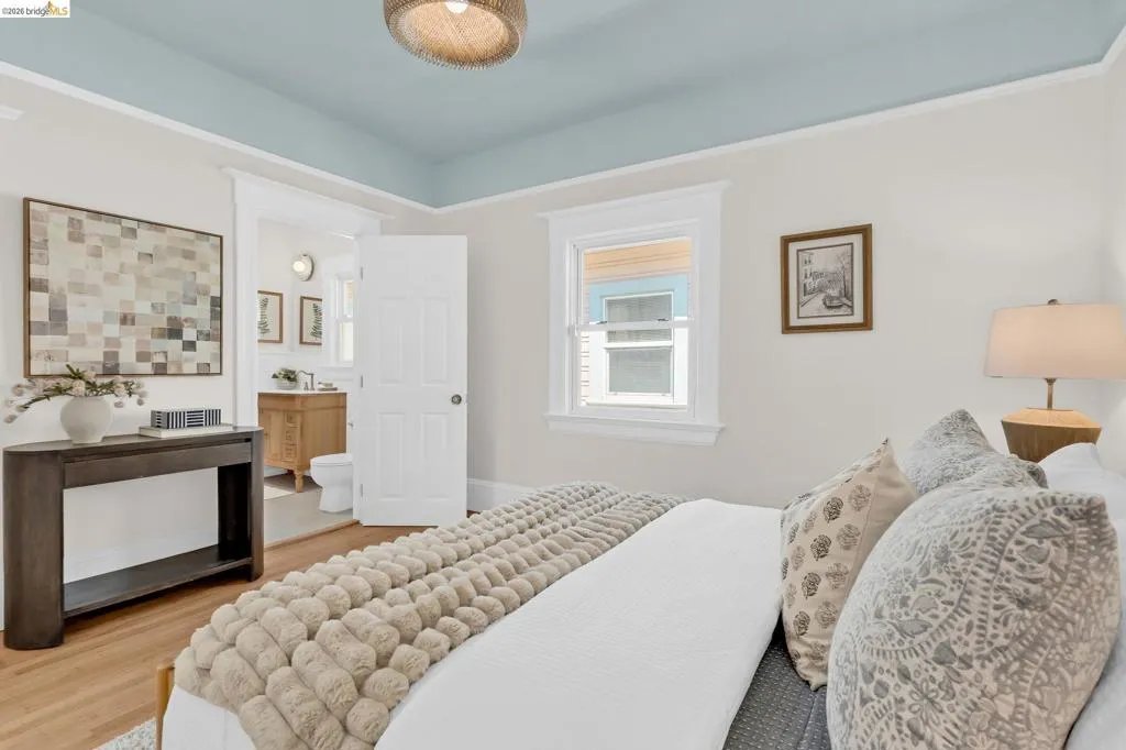 Light wood-finish flooring, a light blue ceiling, and a window with white​​‌​​​​‌​​‌‌​​‌​​​‌‌​​​‌​​‌‌​​‌‌​​‌‌​​​​ trim
