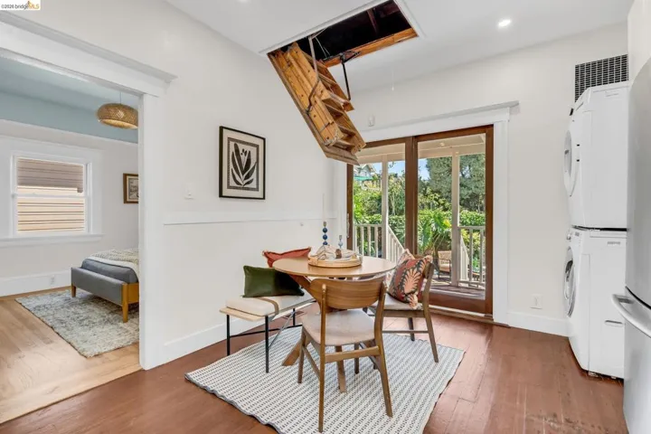 Dark wood-finish flooring with white baseboards, white walls, and a recessed light fixture