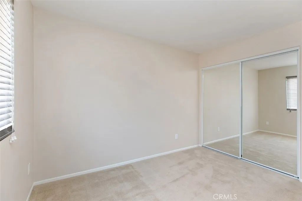 Secondary bedroom, with mirrored closet and wood-blind shades. *flooring to be updated with LVP prior to move-in. Secondary bedroom, with mirrored closet and wood-blind shades. *flooring to be updated with LVP prior to move-in.