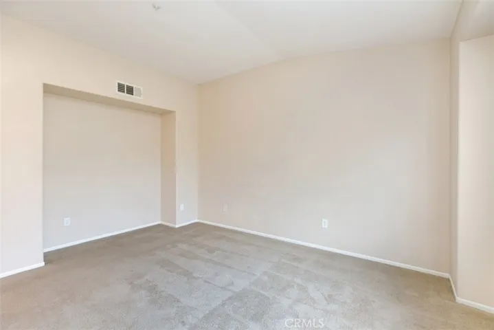 Master bedroom with vaulted ceiling and media/dresser niche. *flooring to be updated with LVP prior to move-in.