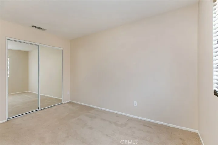 Third bedroom, with mirrored closet and wood-blind shades. *flooring to be updated with LVP prior to move-in.