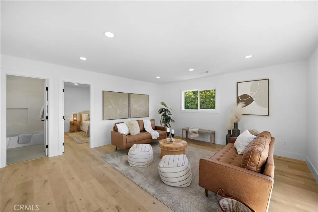 A dramatic hardwood & wrought-iron staircase leads upstairs to an expansive family/bonus room showcasing beautiful views of the greenbelt park.