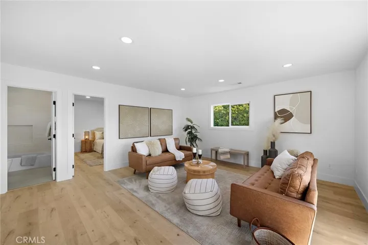 A dramatic hardwood & wrought-iron staircase leads upstairs to an expansive family/bonus room showcasing beautiful views of the greenbelt park.