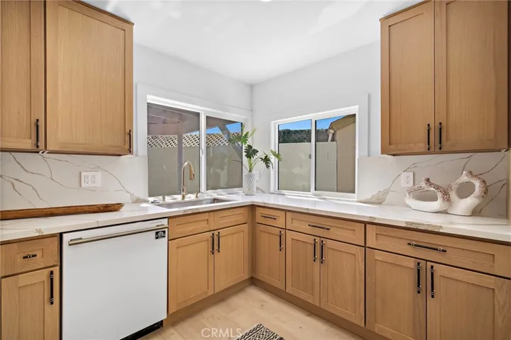 Designed to impress, the kitchen features quartz countertops & backsplash w/waterfall edges, custom soft-close cabinetry & drawers, dramatic black & antique-brass hardware, and a complete suite of professional Forno appliances accented with antique-brass handles.