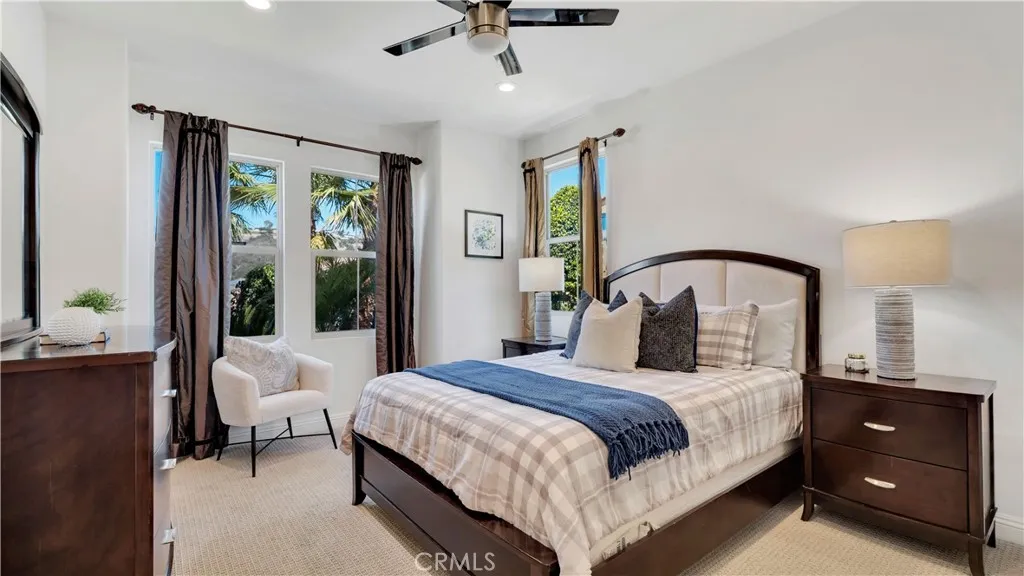 Main-level bedroom with abundant natural light, ceiling fan, and generous space for furnishings Main-level bedroom with abundant natural light, ceiling fan, and generous space for furnishings
