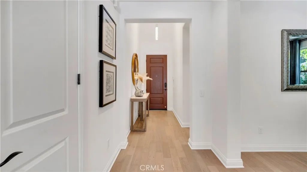 Entry hall view from the dining area, looking toward the front entry and showcasing the home’s welcoming interior flow Entry hall view from the dining area, looking toward the front entry and showcasing the home’s welcoming interior flow