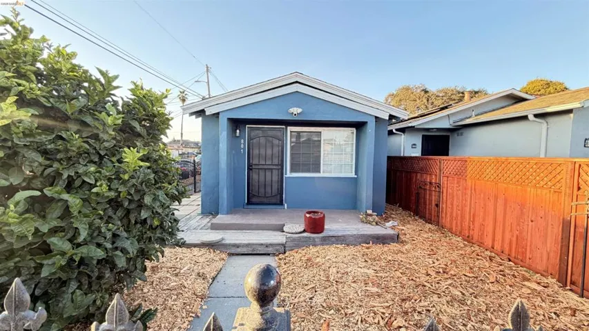 Blue exterior featuring a security screen door, front porch, and wood chip landscaping