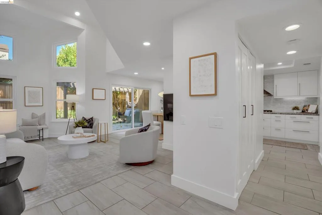 Vaulted ceilings, recessed lighting, and large windows create an airy living space