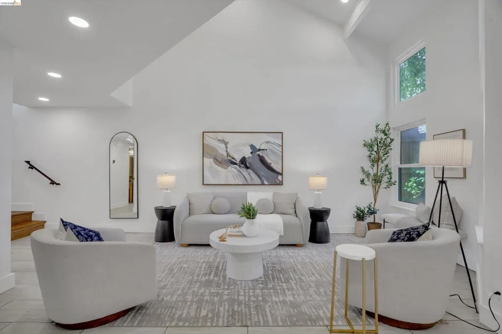 Vaulted ceiling, recessed lighting, wood-finish staircase, large windows, and tile flooring