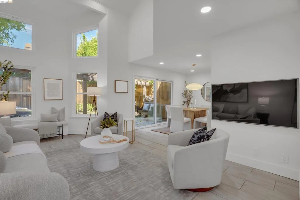 Vaulted ceilings featuring multiple windows, wood-finish flooring, and recessed lighting