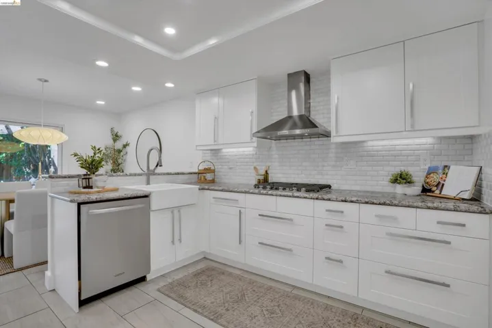Kitchen featuring white cabinetry, subway tile backsplash, stainless steel appliances, granite countertops, and recessed lighting
