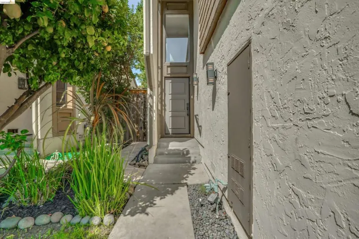 Entryway with a multi-paneled door, sidelight, and stucco exterior