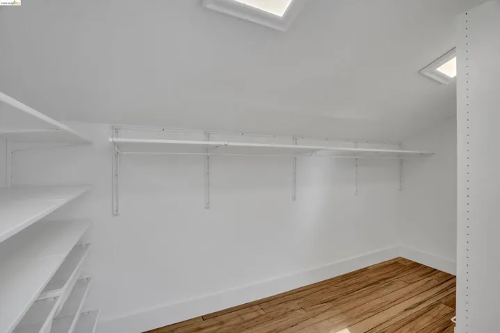 Wood-finish flooring, multiple skylights, built-in shelving, and hanging rods
