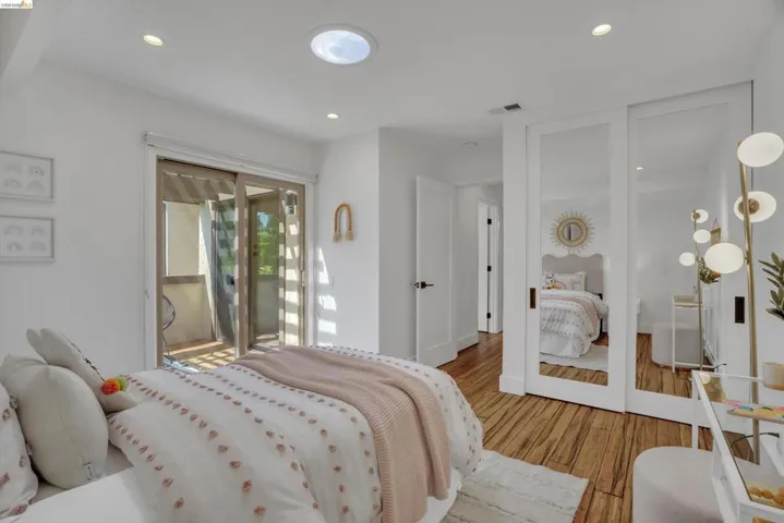 Recessed lighting and a circular skylight illuminate this space with wood-finish flooring