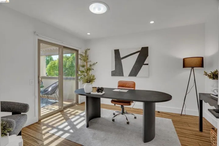 Recessed lighting, wood-finish flooring, sliding glass door, white walls, and a private balcony