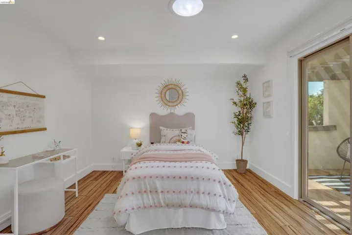 Wood-finish flooring, recessed lighting, ceiling light fixture, white baseboards, and sliding glass door