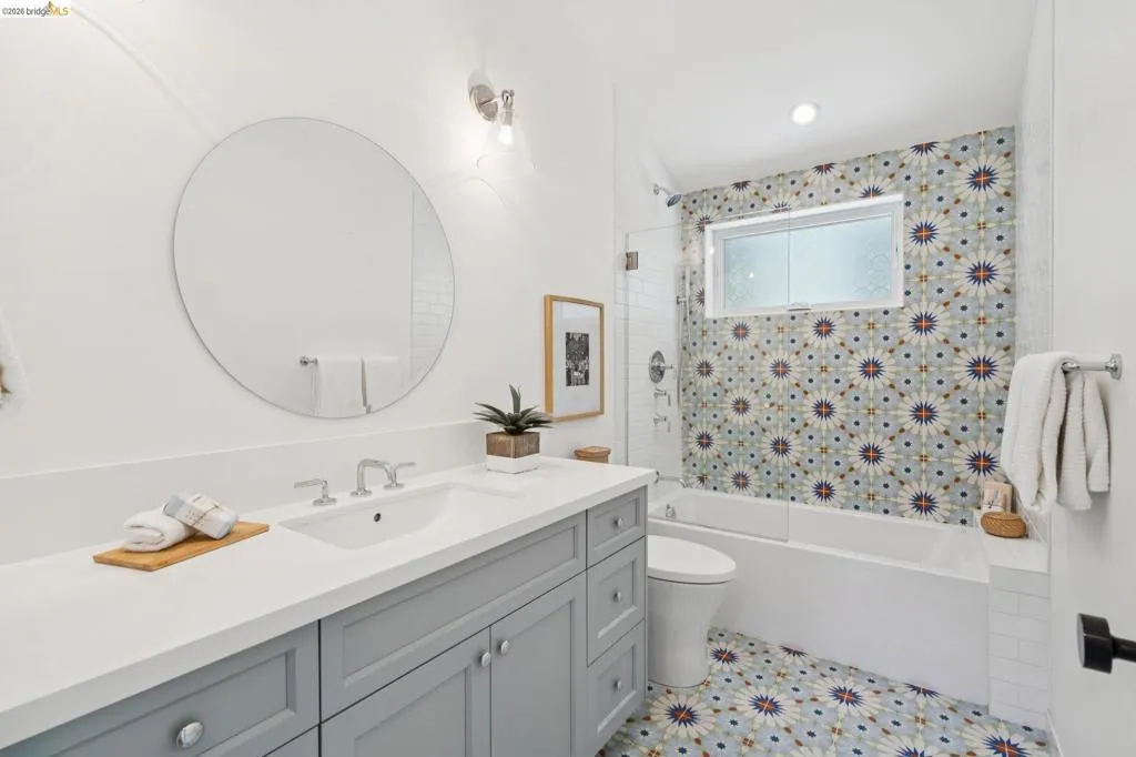 Single vanity with a vessel sink, a full-width mirror, and a built-in bathtub Single vanity with a vessel sink, a full-width mirror, and a built-in bathtub
