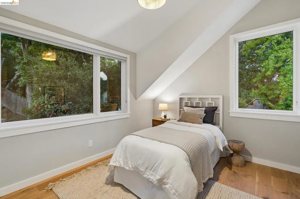 Sloped ceiling design, wood-finish flooring, recessed lighting, and multiple windows with white trim Sloped ceiling design, wood-finish flooring, recessed lighting, and multiple windows with white trim