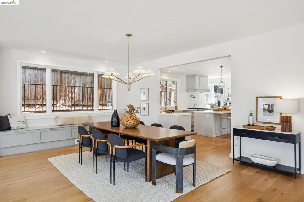 Open-concept living space featuring wood-finish flooring, a contemporary chandelier, recessed lighting, and a built-in window bench with storage Open-concept living space featuring wood-finish flooring, a contemporary chandelier, recessed lighting, and a built-in window bench with storage