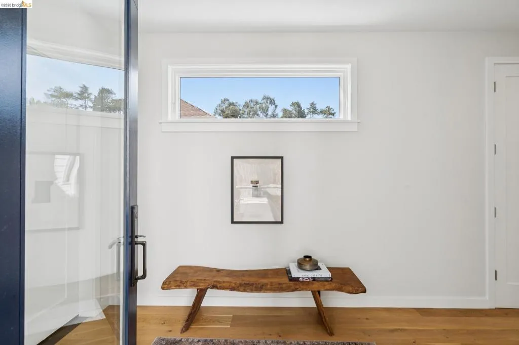 Hardwood flooring, white painted walls, transom window, and a white interior door with dark hardware Hardwood flooring, white painted walls, transom window, and a white interior door with dark hardware
