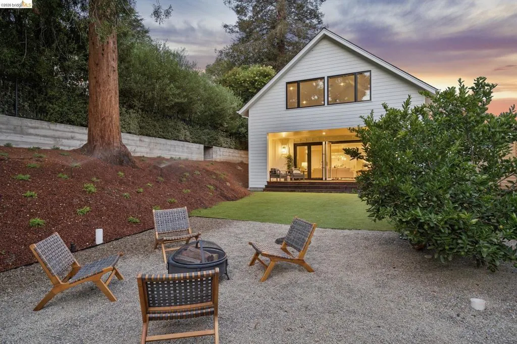 Rear exterior with a pitched roofline, large upper windows, and a covered patio featuring sliding glass doors Rear exterior with a pitched roofline, large upper windows, and a covered patio featuring sliding glass doors