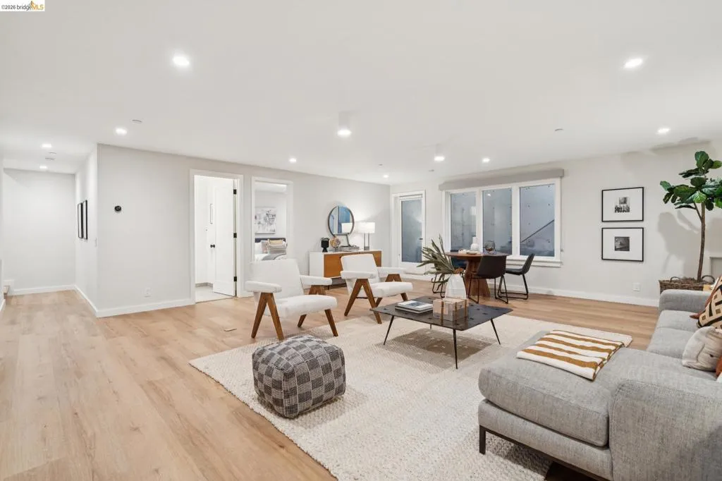 Recessed lighting, wood-finish flooring, white walls, multiple windows, and interior doors with black hardware Recessed lighting, wood-finish flooring, white walls, multiple windows, and interior doors with black hardware