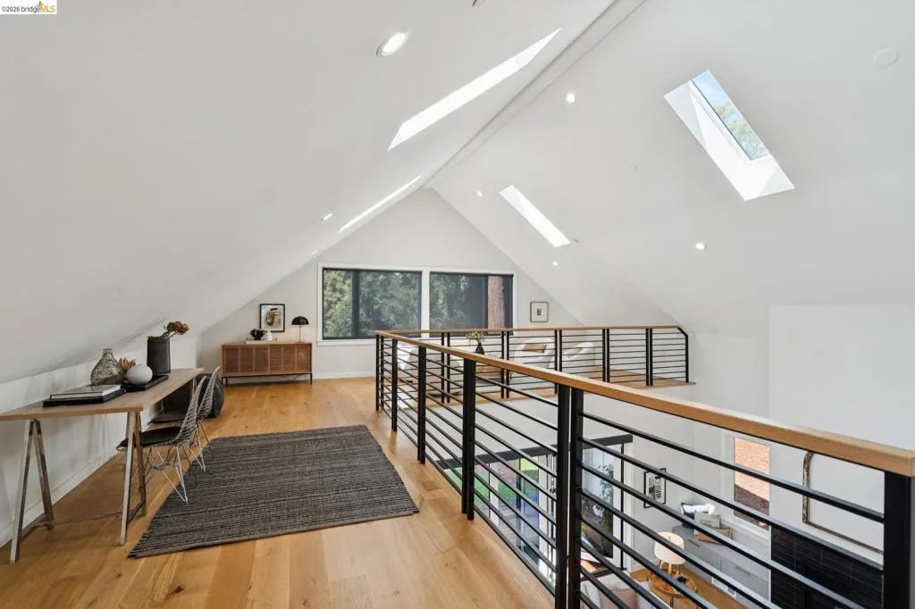 Vaulted ceiling with multiple skylights, recessed lighting, wood-finish flooring, and horizontal bar railing Vaulted ceiling with multiple skylights, recessed lighting, wood-finish flooring, and horizontal bar railing